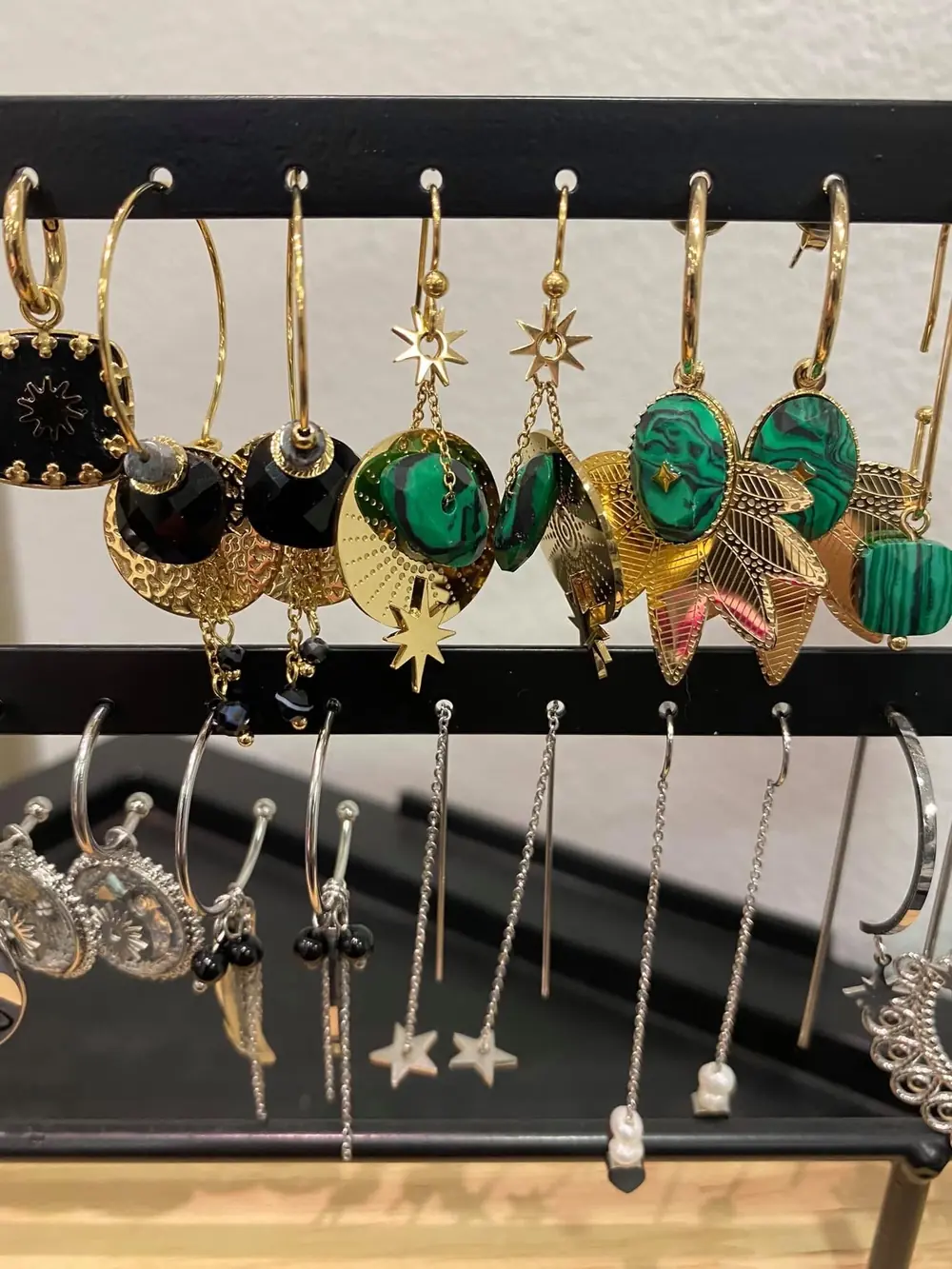 Boucles d’oreilles dorées, noires et vertes présentées au salon.
