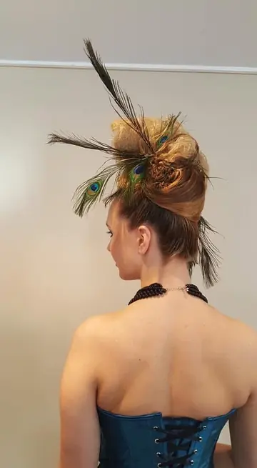 Chignon haut avec des plumes de paon, vu de dos.