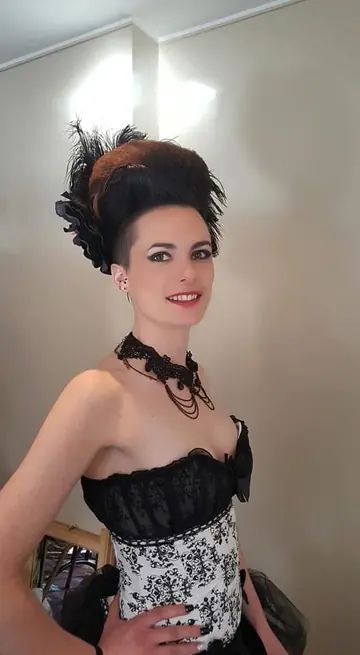 Coiffure haute ornée d’un accessoire noir, portée avec une tenue de soirée.