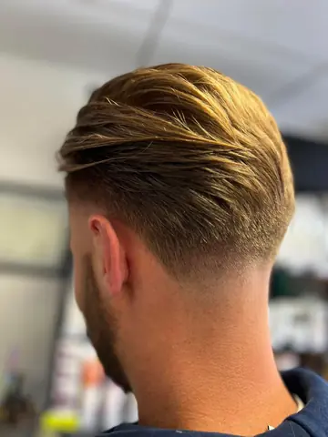 Coupe courte homme avec un dégradé soigné sur la nuque.